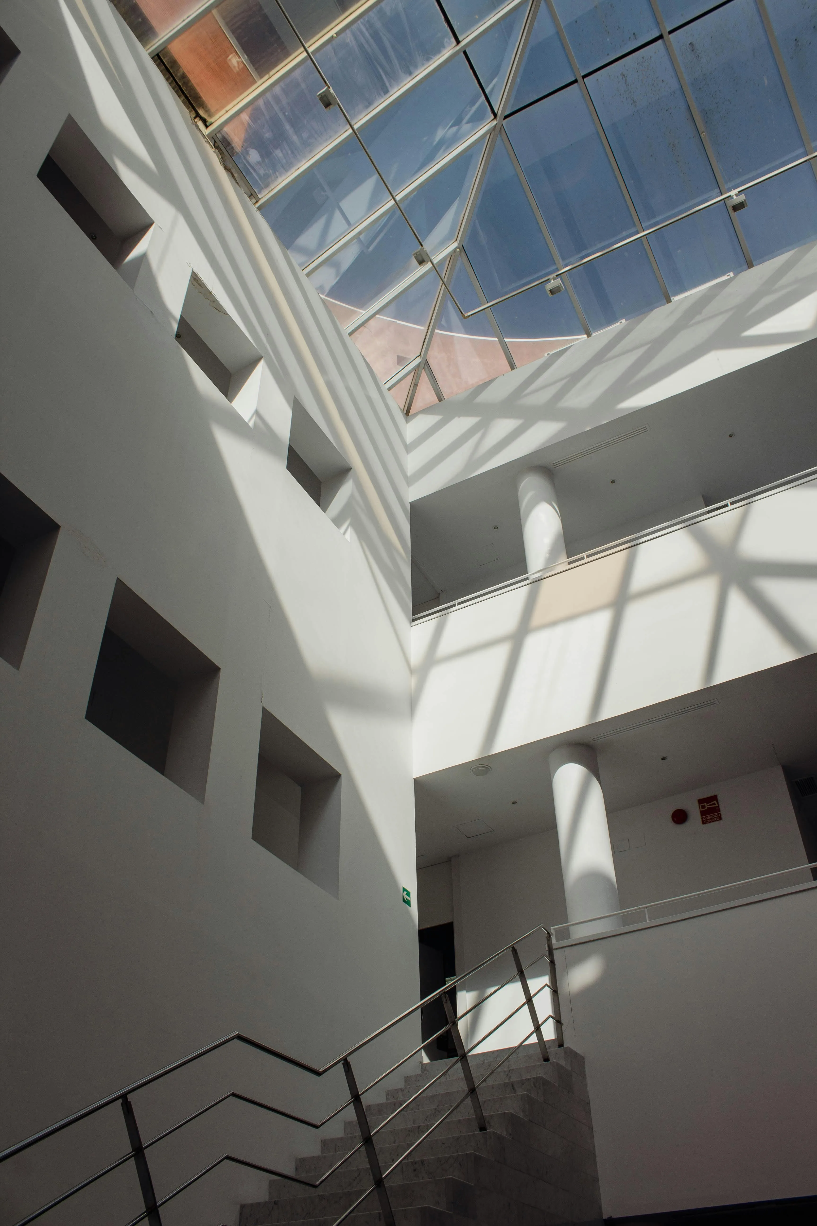 Atrio interior con luz cenital, doble altura y escalera.