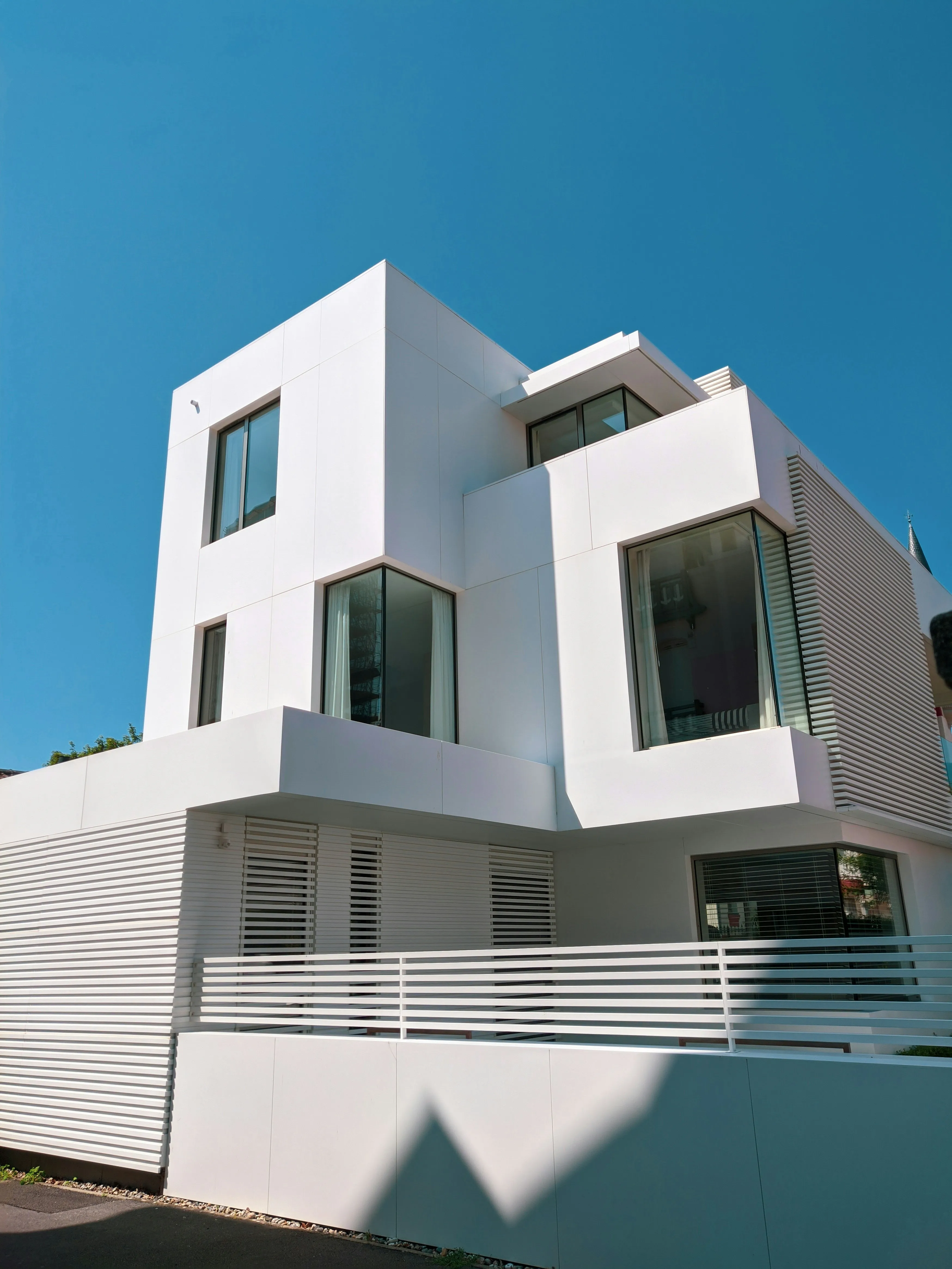Casa con fachada blanca moderna tras remodelación exterior.